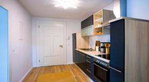 a kitchen with black cabinets and a white door at Parkresidenz Lychen, Ferienwohnung 3 in Lychen