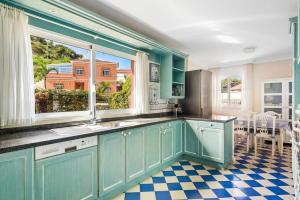 cocina con armarios azules y suelo a cuadros en Villa Artigar, garden, swimming pool and bbq. en Puerto de la Cruz