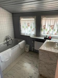 a bathroom with a tub and a sink at Dworek Pokoje Gościnne in Olsztyn