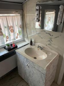 a bathroom with a sink and a mirror at Dworek Pokoje Gościnne in Olsztyn