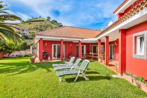 um grupo de cadeiras no pátio de uma casa em Villa Artigar, garden, swimming pool and bbq. em Puerto de la Cruz