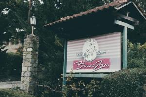 a sign for a dunglaw company next to a building at Bourazani Wild Life Resort in Konitsa