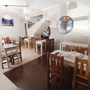 a restaurant with tables and chairs and a clock on the wall at Hotel Are Pora in Gualeguaychú