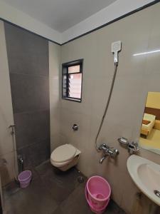 a bathroom with a toilet and a sink and a shower at Hotel Midtown Inn in Trimbak
