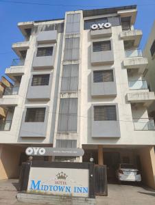 a large building with a sign in front of it at Hotel Midtown Inn in Trimbak