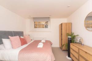 a bedroom with a large bed and a dresser at Panda Sanctuaries, Kensington Chapel Apartment in Bath