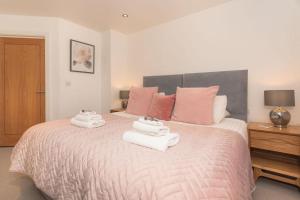 1 dormitorio con 1 cama grande y toallas. en Panda Sanctuaries, Kensington Chapel Apartment, en Bath