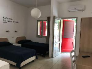 a room with a bed and a red door at Hotel Fontane Bianche in Fontane Bianche
