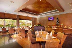 a restaurant with tables and chairs and a christmas tree at Park Plaza Chennai OMR in Chennai