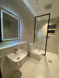 جولدن نيو قريش جده في جدة: حمام أبيض مع حوض ومرحاض
