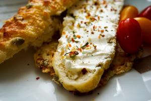 a piece of bread with cream cheese and cherries on a plate at Parkresidenz Lychen, Ferienwohnung 9 in Lychen