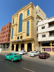 eine Gruppe von Autos, die vor einem Gebäude geparkt sind in der Unterkunft Golden New Quraish Jeddah in Dschidda