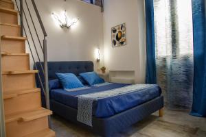 Ce lit bleu se trouve dans une chambre avec un escalier. dans l'établissement La Perla della Cattedrale luxury home, à Agrigente