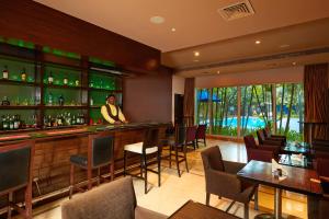 a man standing at a bar in a restaurant at Park Plaza Chennai OMR in Chennai