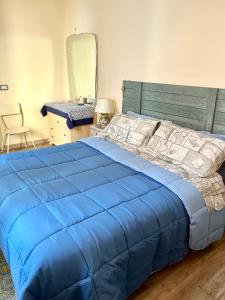 a bedroom with a blue bed with a blue comforter at Casa Filemone in Syracuse