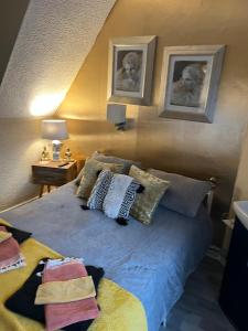 a bedroom with a bed with two pictures on the wall at The Southwold Guest House in Skegness