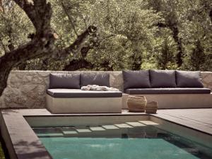 a couch sitting on a deck next to a swimming pool at Zayn Luxury Villas, a Serene Escape, By ThinkVilla in Zakynthos Town