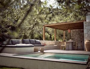 a swimming pool in a backyard with a couch and a table at Zayn Luxury Villas, a Serene Escape, By ThinkVilla in Zakynthos Town