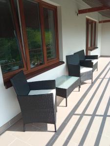una fila de sillas y mesas en un patio en Dom przy lesie en Zawadka