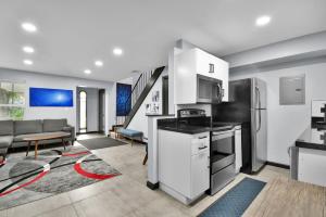 een woonkamer met een keuken en een woonkamer met een bank bij Wilton Manors Villas - Florida Furnished Living in Fort Lauderdale