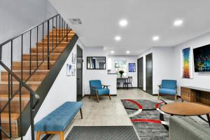 een woonkamer met een trap en blauwe stoelen bij Wilton Manors Villas - Florida Furnished Living in Fort Lauderdale