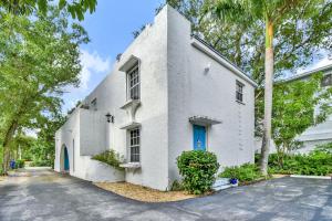 une maison blanche avec une porte bleue dans une rue dans l'établissement Wilton Manors Villas - Florida Furnished Living, à Fort Lauderdale
