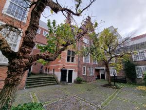 a brick building with a tree in front of it at Het Waterhof in Leiden