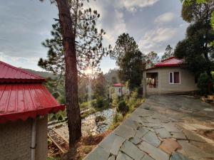 dom z czerwonym dachem i drzewem w obiekcie Majkhali Woods, Ranikhet, By Himalayan Eco Lodges w mieście Ranikhet