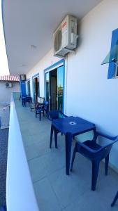 een blauwe tafeltennistafel en stoelen op een balkon bij Pousada Miguel Penha Sc in Penha