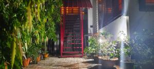 a red door leading to a courtyard with plants at Gruham Homestay in Jorhāt