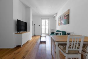 a living room with a table and a tv at La Dolce Vita - Luxury Stylish Flat in Trastevere 60sqm in Rome