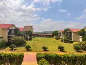 本迪布爾的住宿－Bandipur Wildlife Resort & Spa, Bandipur，一座拥有房屋和树木的大型草地庭院