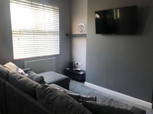 un soggiorno con divano e TV a schermo piatto di House in Hemingfield a Wombwell