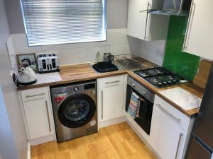 a small kitchen with a washing machine in it at House in Hemingfield, Ideal for Contractors and Long Stays in Wombwell