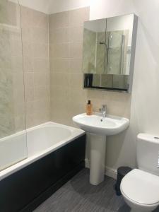 a bathroom with a sink and a tub and a toilet at House in Hemingfield in Wombwell