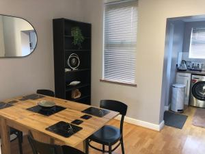 a dining room table with chairs and a mirror at House in Hemingfield in Wombwell