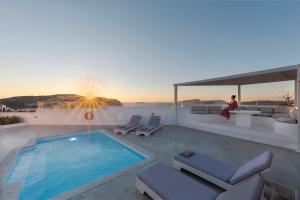 a person sitting on the roof of a house with a swimming pool at Hemera Holiday Home villa on Santorini in Akrotiri