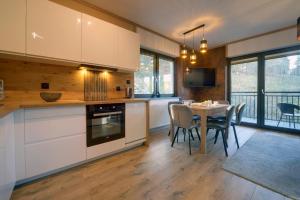 una cucina e una sala da pranzo con tavolo e sedie di Apartamenty Sun Seasons 24 - Karpatia a Karpacz