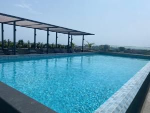 a large swimming pool with blue water and chairs at The Lennox Luxury Suites & Apartments in Accra