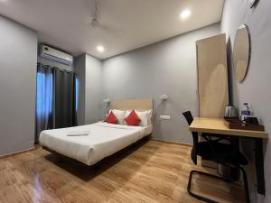 um quarto com uma cama, uma mesa e uma secretária em Hotel Zen Garden em Guwahati