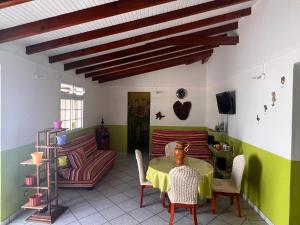a living room with a table and chairs and a couch at La Marie-Galantaise dans la nature in Beaurenom