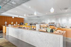 a large kitchen with a counter with food at Best Western Plus Sthlm Bromma in Stockholm