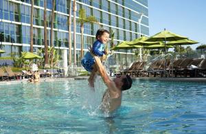 a man holding a child in a swimming pool at Hyatt Regency Long Beach in Long Beach