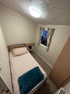 a small bedroom with a bed and a window at Two Bedroom Willerby Parkhome in Uddingston, Glasgow in Uddingston