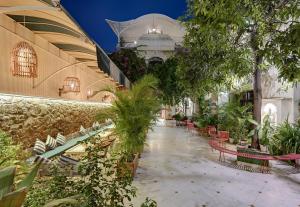 乌代浦Swaroop Vilas - Lake Facing Boutique Hotel的长椅和植物的建筑的庭院