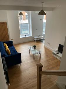 a living room with a blue couch and a coffee table at City Centre 1 Bed Sleeps 4 H5 in Hull