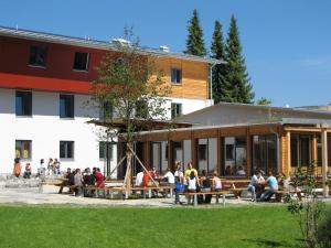 eine Gruppe von Personen, die außerhalb eines Gebäudes sitzen in der Unterkunft Jugendherberge Garmisch-Partenkirchen - membership required! in Garmisch-Partenkirchen