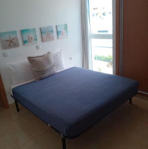 uma cama azul num quarto com uma janela em Lovely - Luxury 3 Bedrooms 500m from the Beach. em Santa Maria