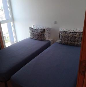 um quarto com 2 camas com almofadas e uma janela em Lovely - Luxury 3 Bedrooms 500m from the Beach. em Santa Maria