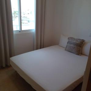 a white bed in a room with a window at Lovely - Luxury 3 Bedrooms 500m from the Beach. in Santa Maria